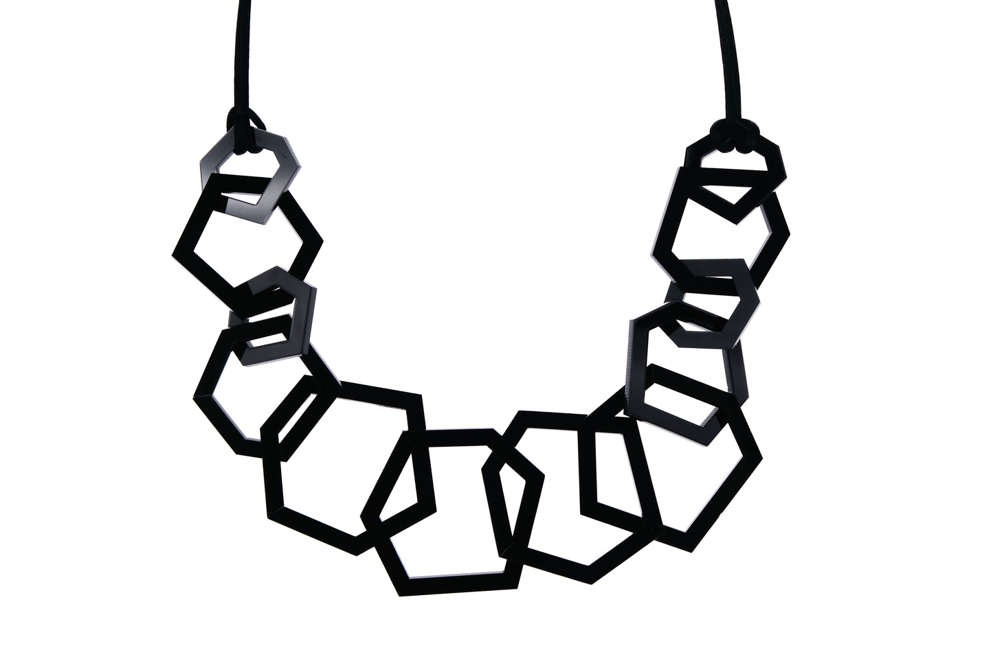 Geometric necklace with black and white hexagonal beads on a white background