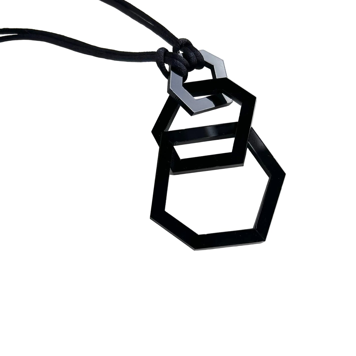 Black geometric pendant necklace on a white background