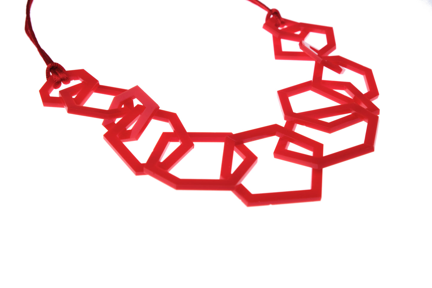 Red geometric necklace on a white background