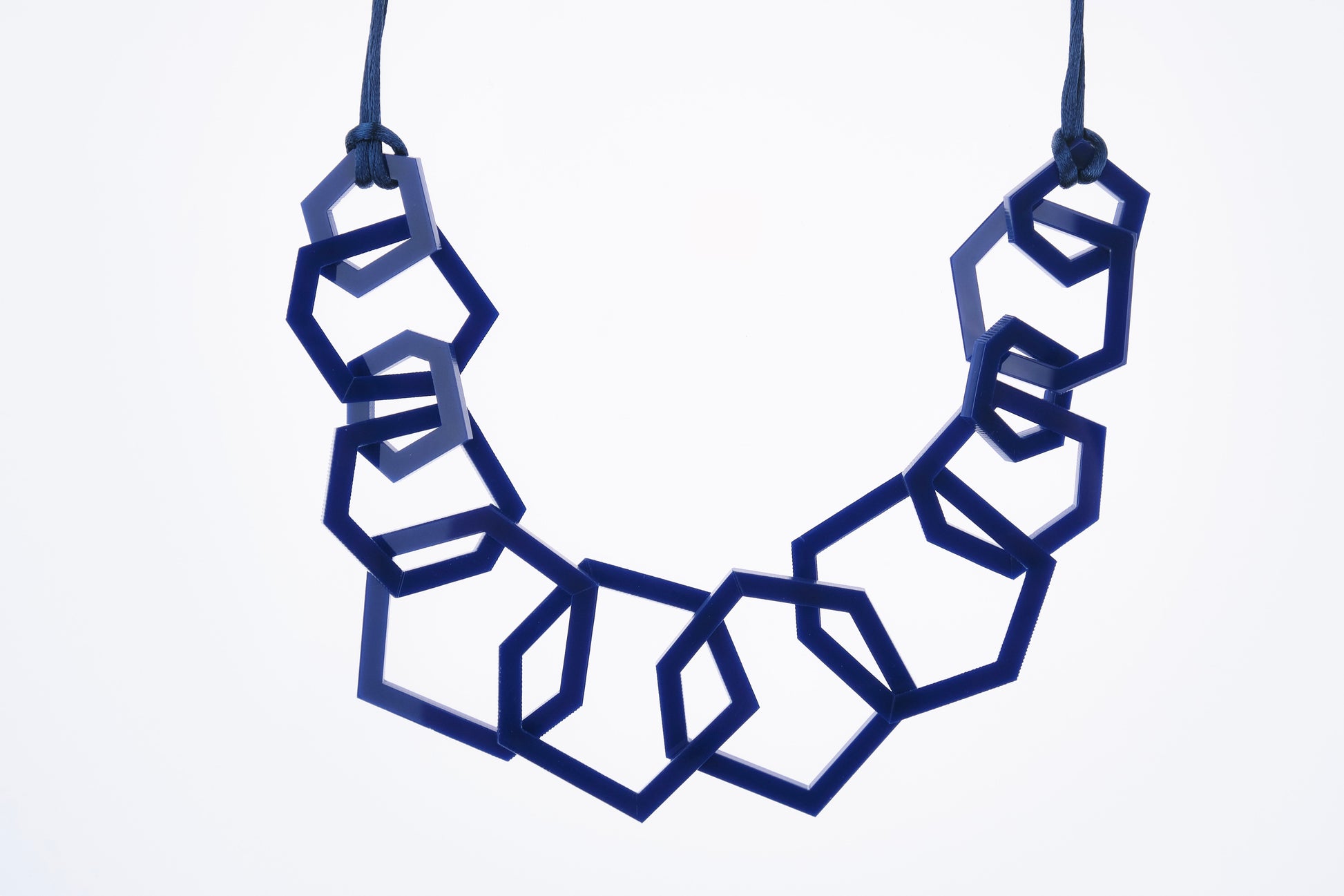 Navy Blue Geometric necklace with blue hexagonal shapes on a white background