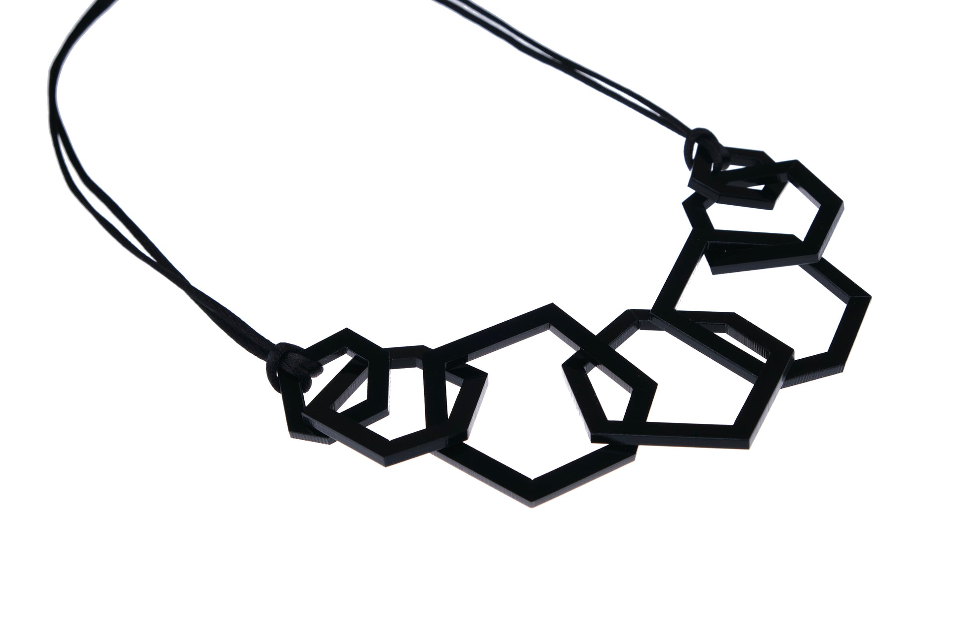 Black geometric necklace on a white background