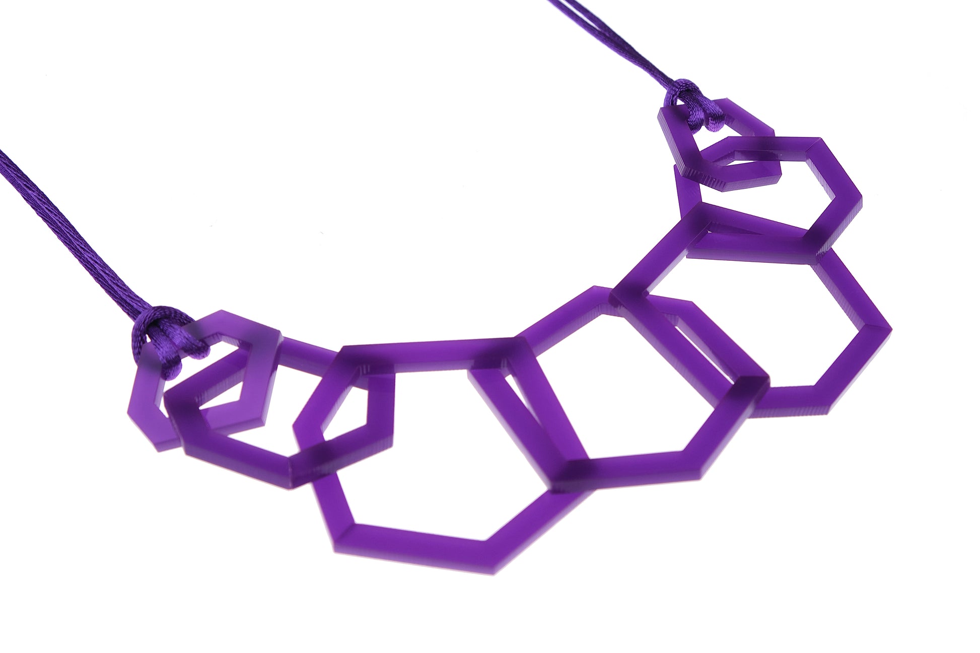 Close up of Purple geometric acrylic necklace on a white background