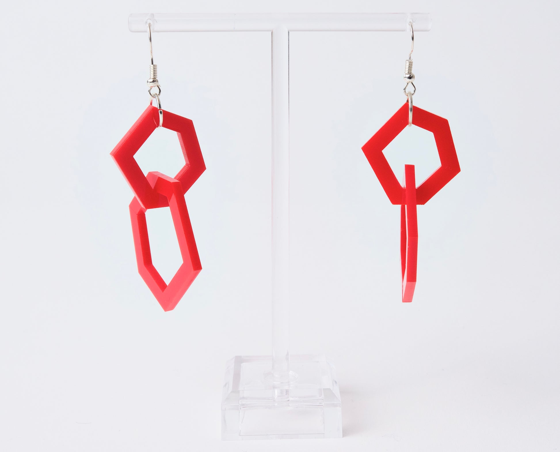 Red geometric earrings on a white background
