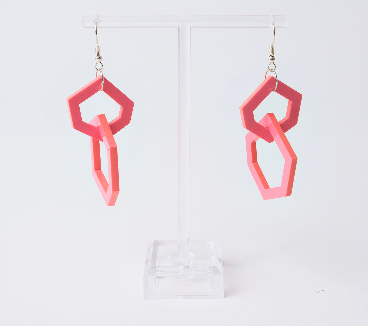 Pink geometric earrings on a white background