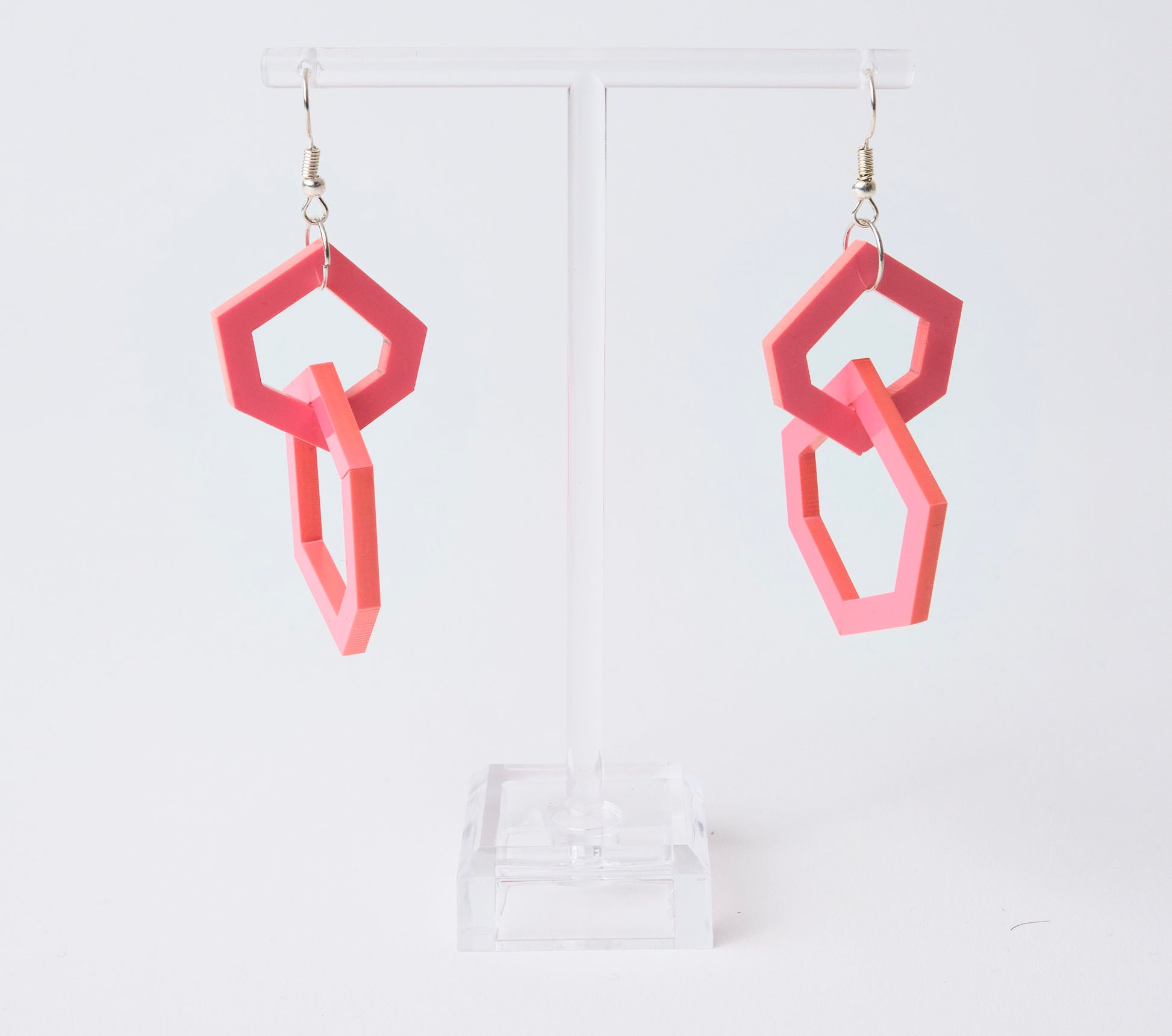 Pink geometric earrings on a white background