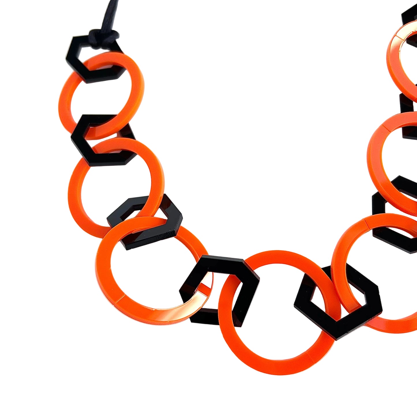 Necklace with orange and black geometric links on a white background