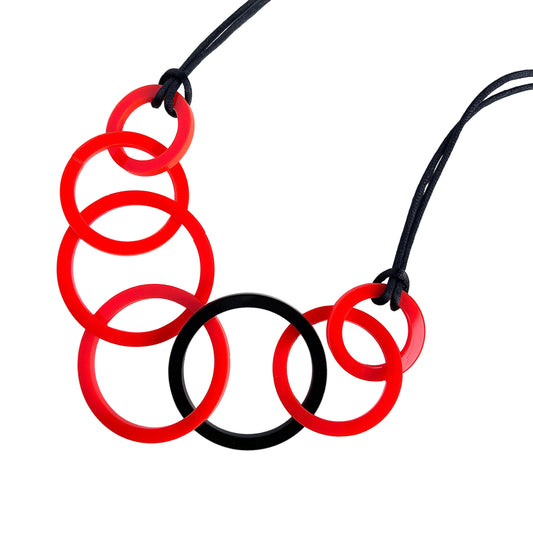 Necklace with red and black circular links on a white background