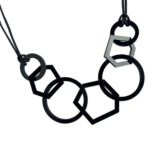 Black and silver geometric necklace on a white background