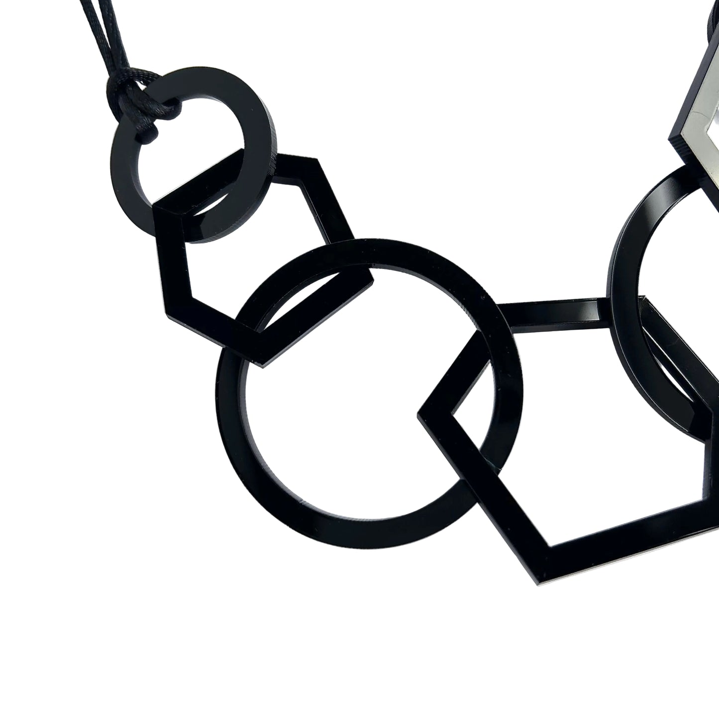 Black geometric necklace on a white background