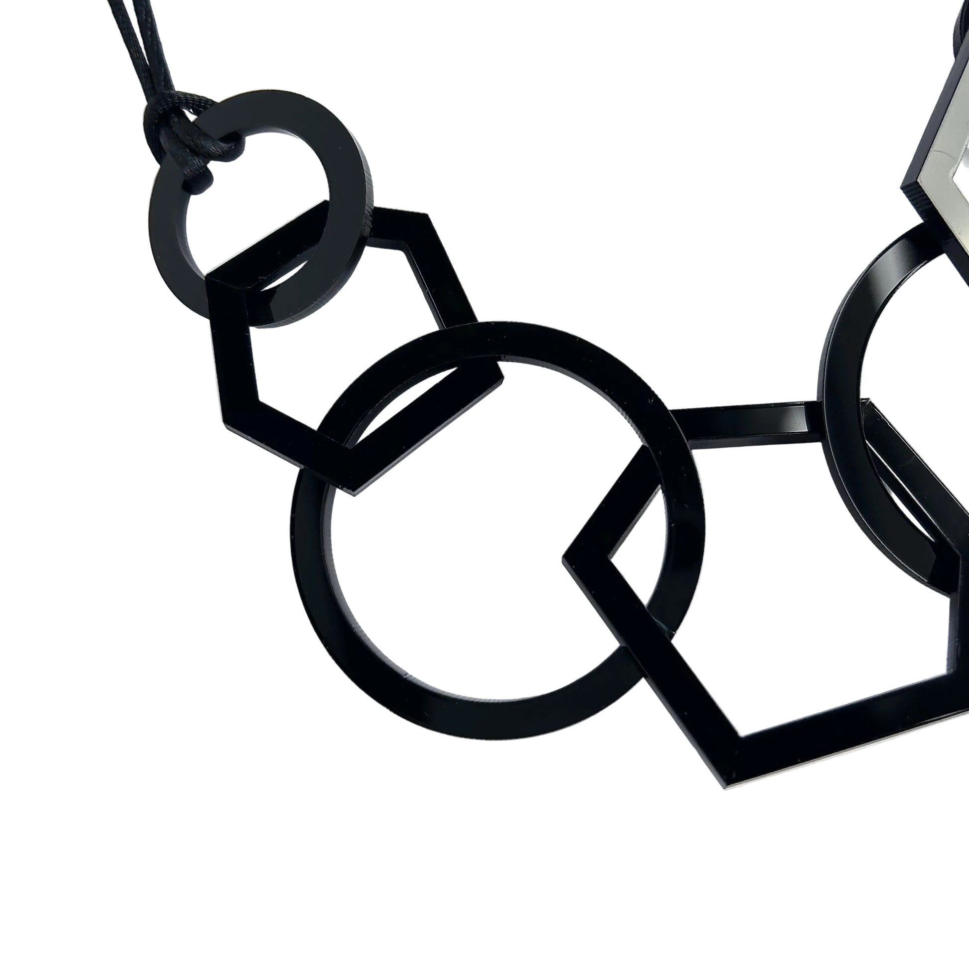 Black geometric necklace on a white background