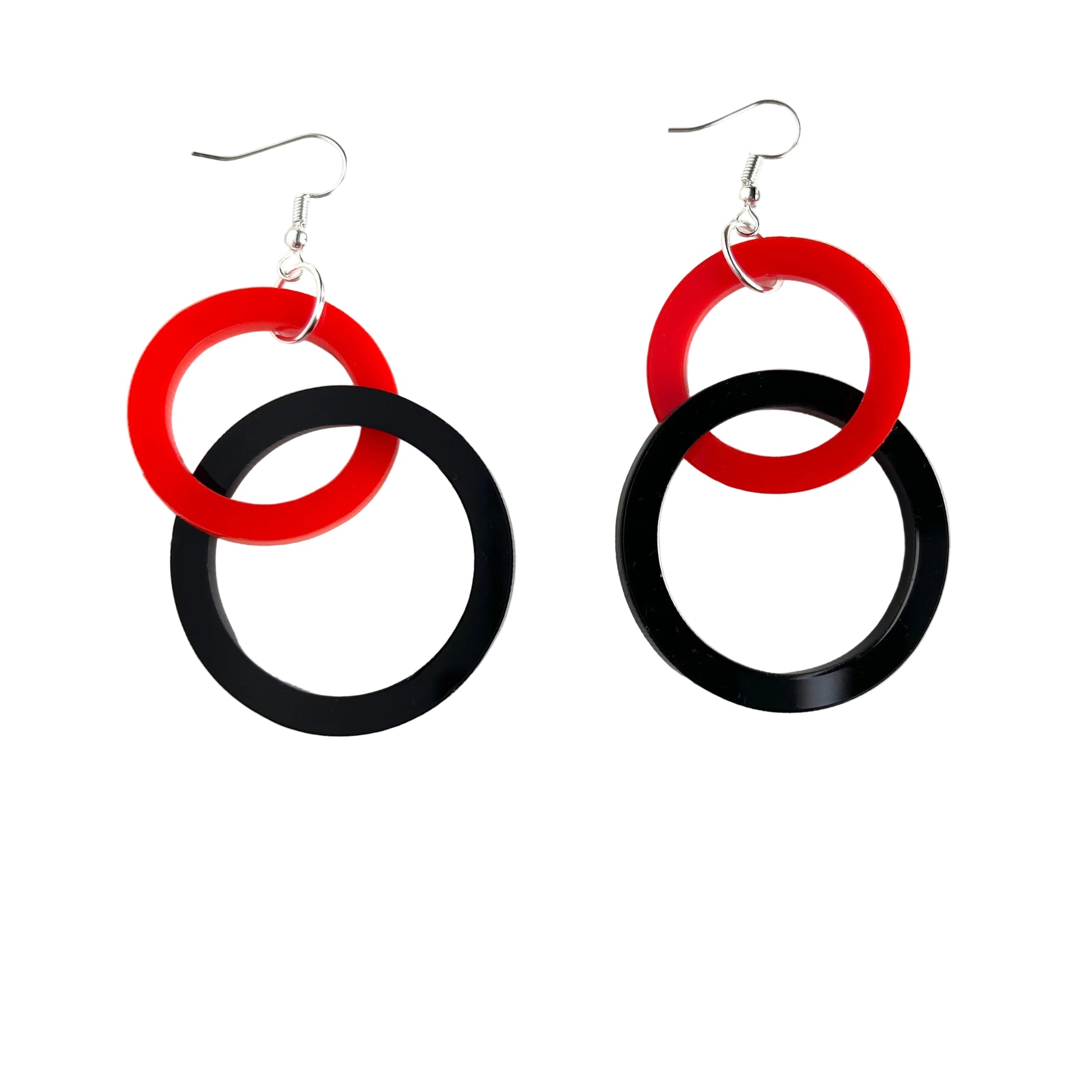 Pair of earrings with red and black circular design on a white background
