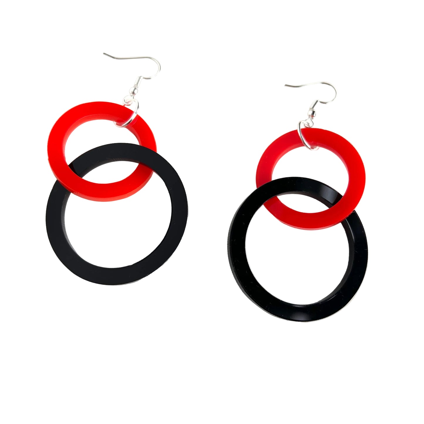 Pair of earrings with red and black circular designs on a white background