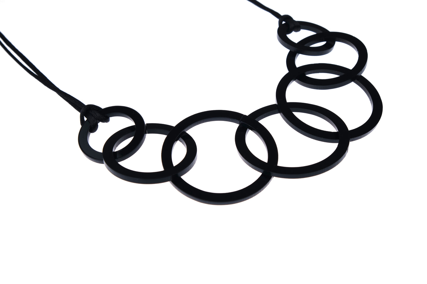 Black circular necklace on a white background