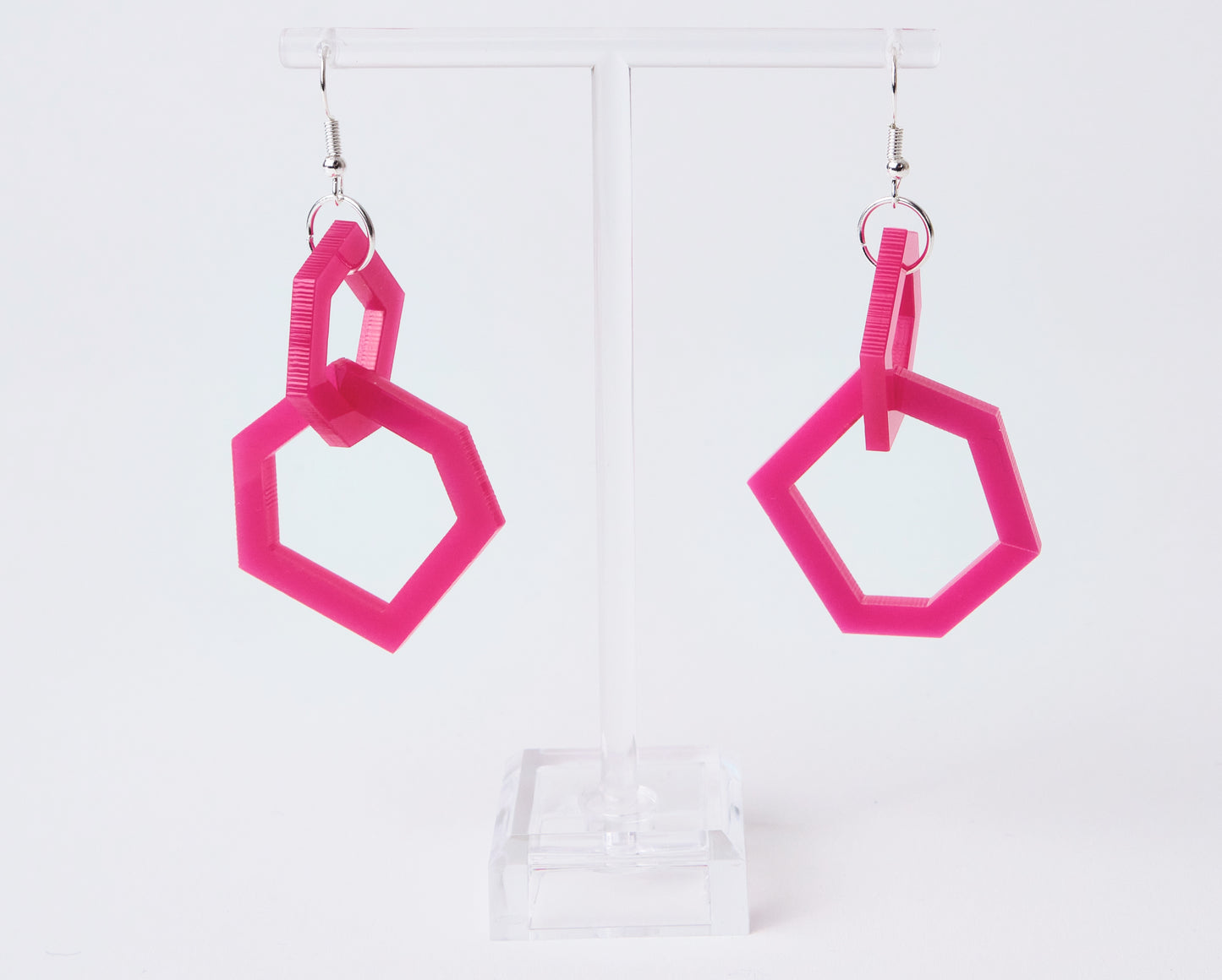 Pink geometric earrings on a white background