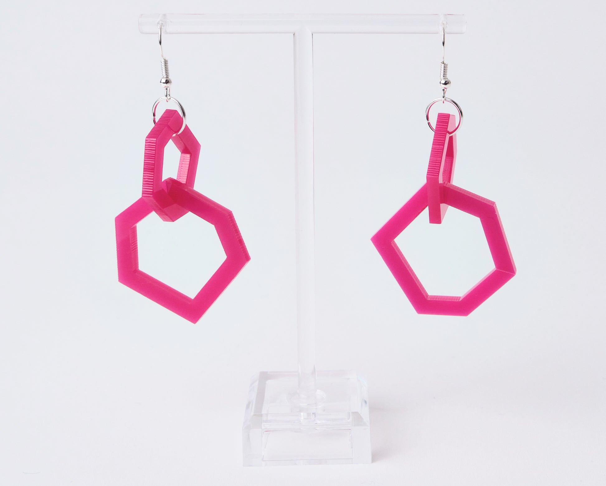 Pink geometric earrings on a white background