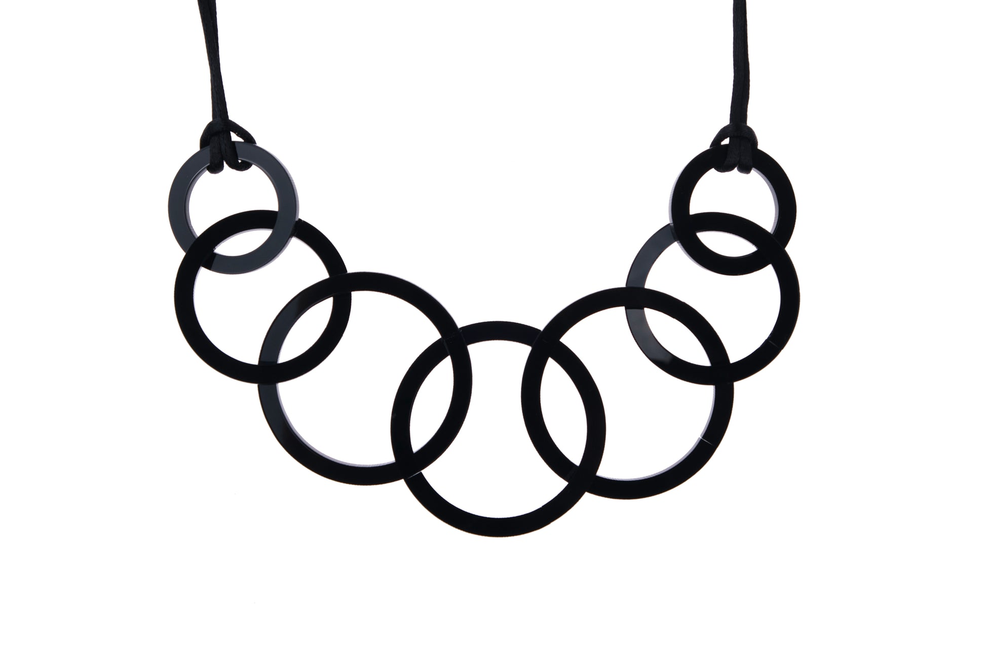 Black circular acrylic necklace on a white background