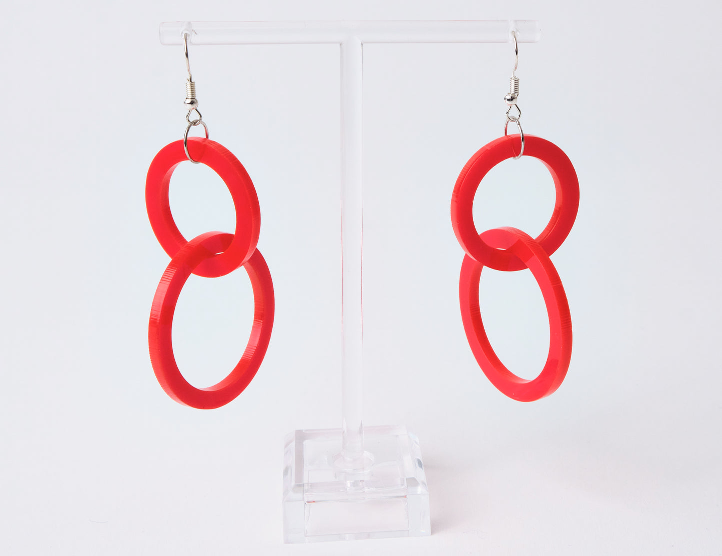Red circular earrings on a white background
