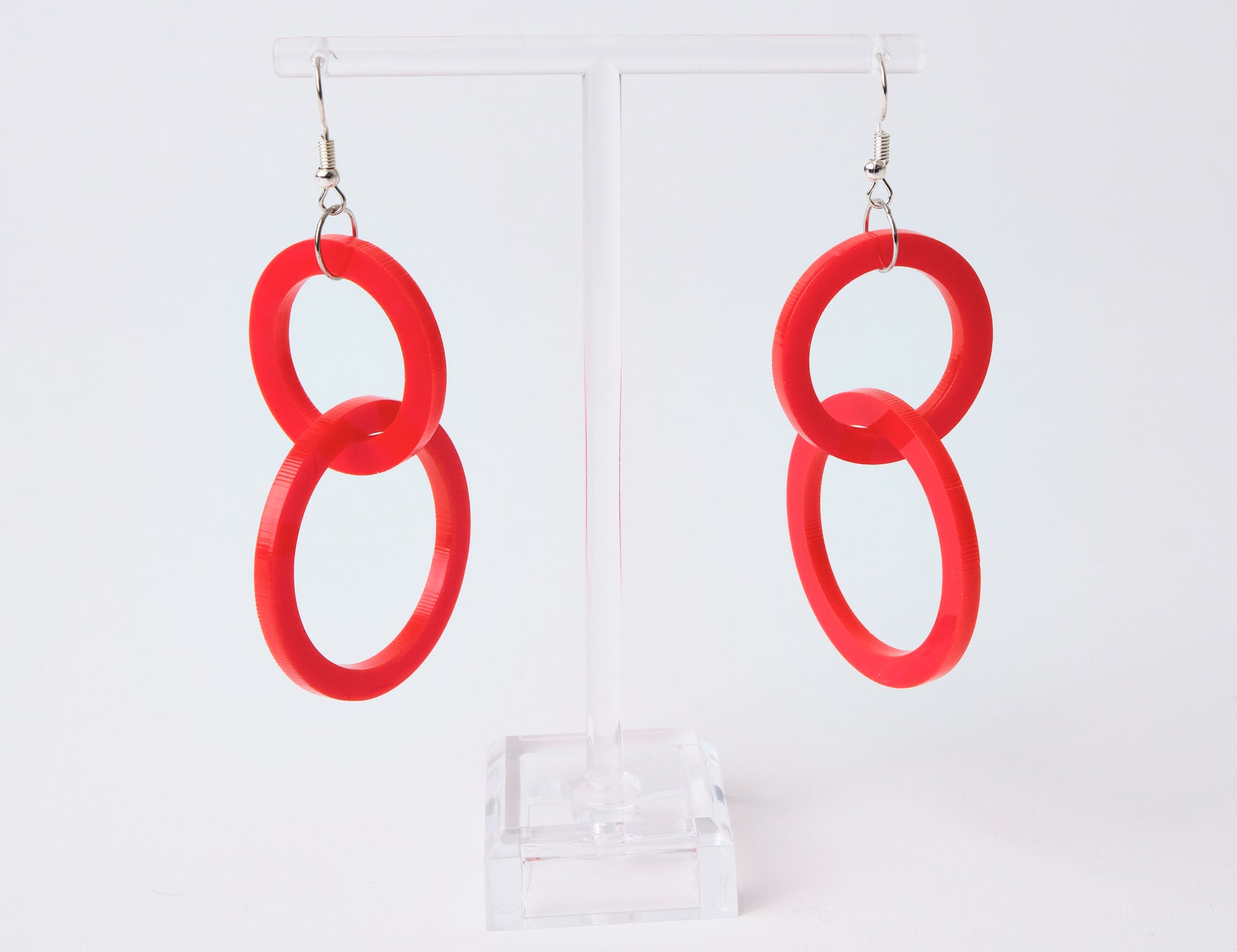 Red circular earrings on a white background