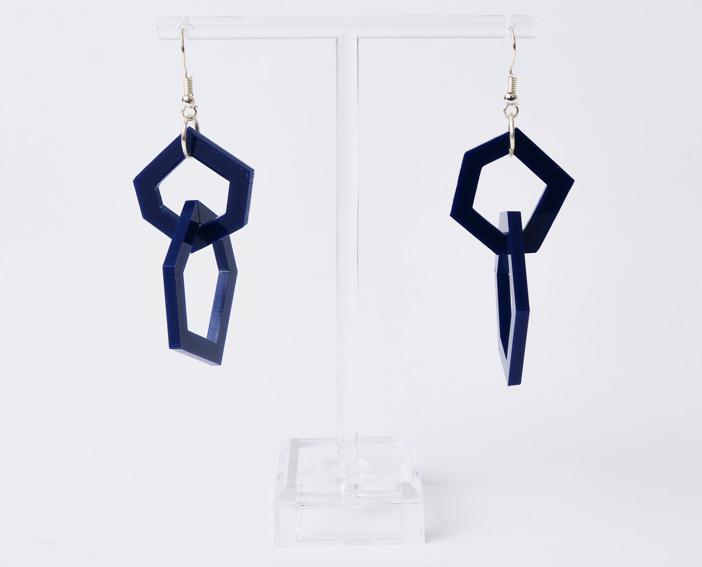 Navy blue geometric earrings on a white background