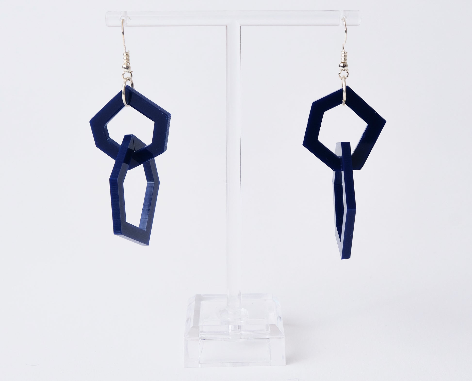 Navy blue geometric earrings on a white background