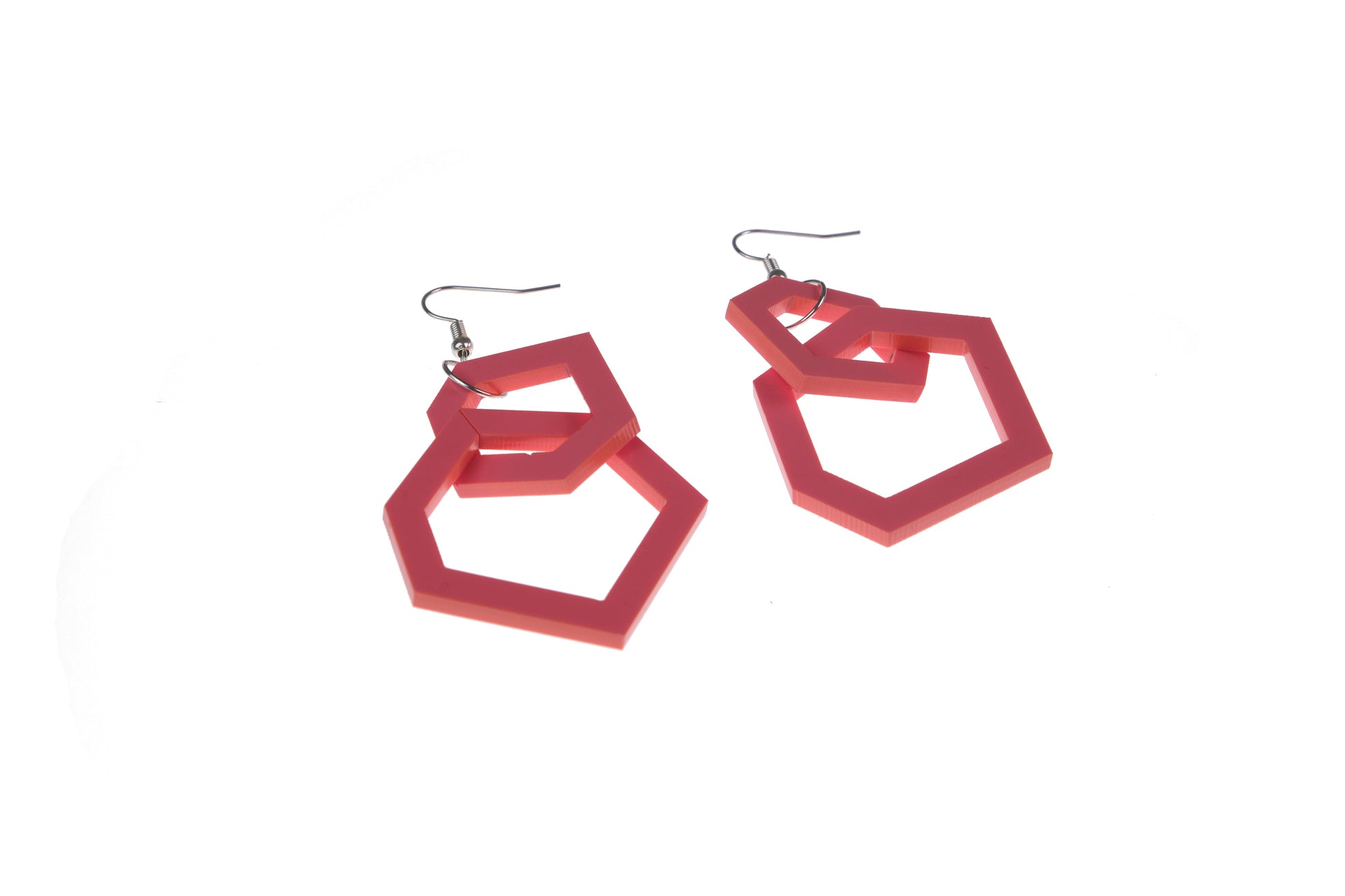 coral pink geometric hoop earrings on a white background